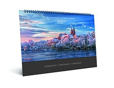 Kalender 2027 vom Advent-Verlag mit Stadtansicht und Fluss im Hintergrund, farbenfrohes Himmelsszenario, spiralförmiger Kalender.