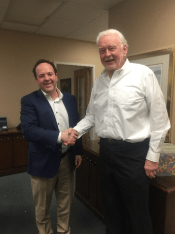 Picture of Henry Risman, President of the Risman Agencies and Thomas Ward, Owner of the T.F. Ward Insurance Agency shaking hands after signing the sale documents completing the acquisition of the Ward Agency by the Risman Agencies.
