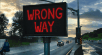 Highway ramp with illuminated wrong way sign and safety technology used to prevent wrong-way driving crashes