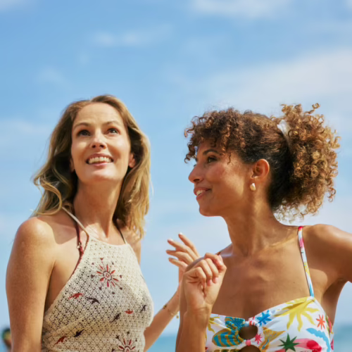 Two women outdoors in summer looking up at the sky