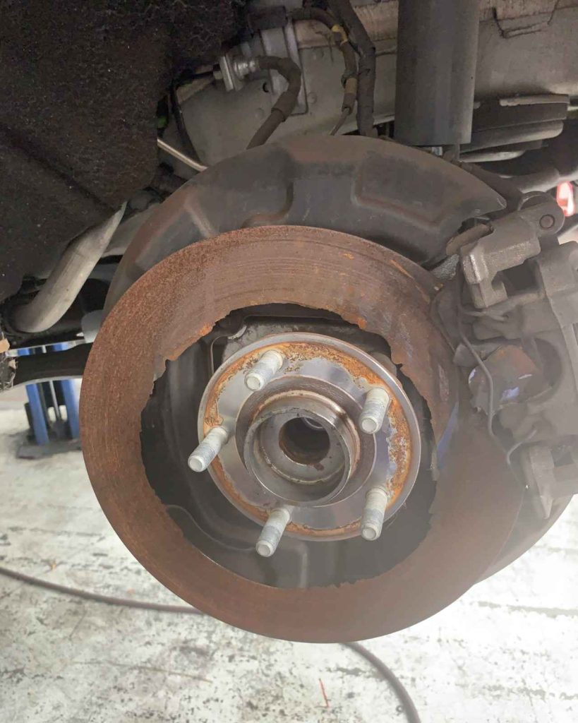 Rusty brake rotor and wheel hub showing worn components.