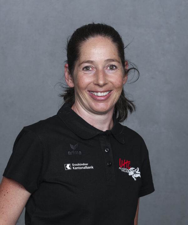 UHC Alligator Malans Frau in schwarzem UHC Polo-Shirt vor grauem Hintergrund.