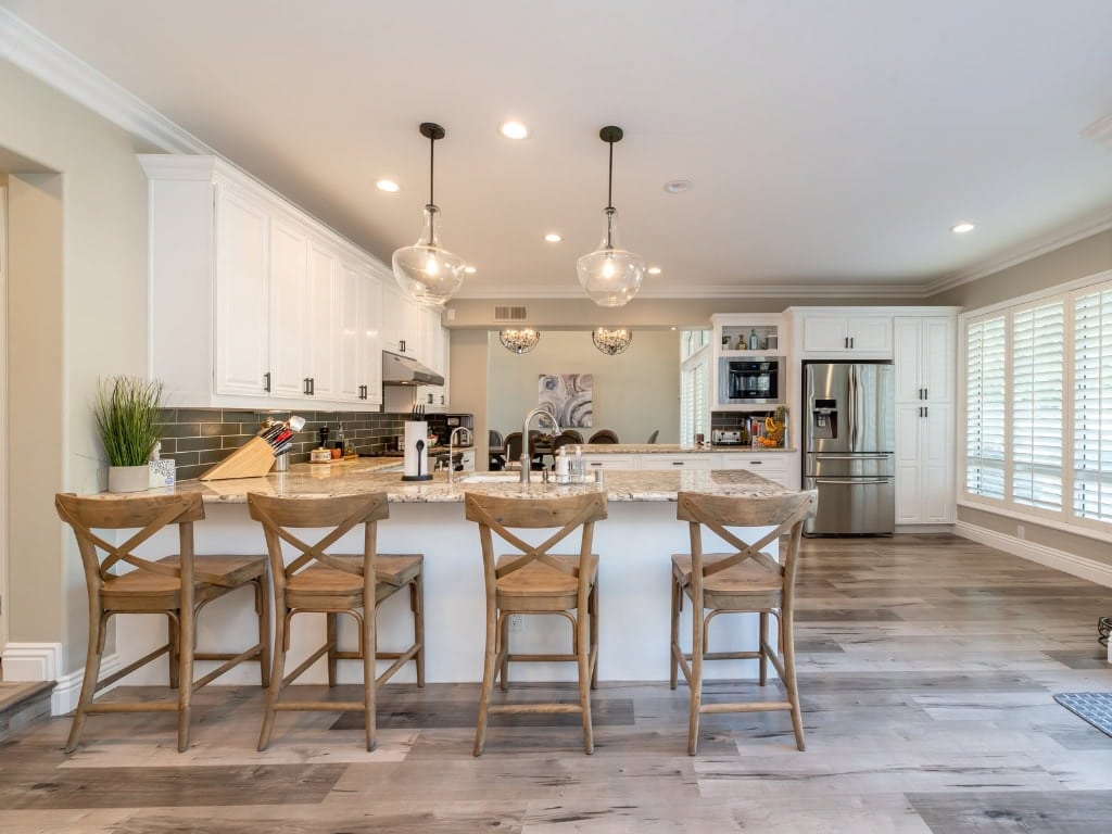 Bright, spacious kitchen with marble countertop, stainless steel appliances, and natural light.