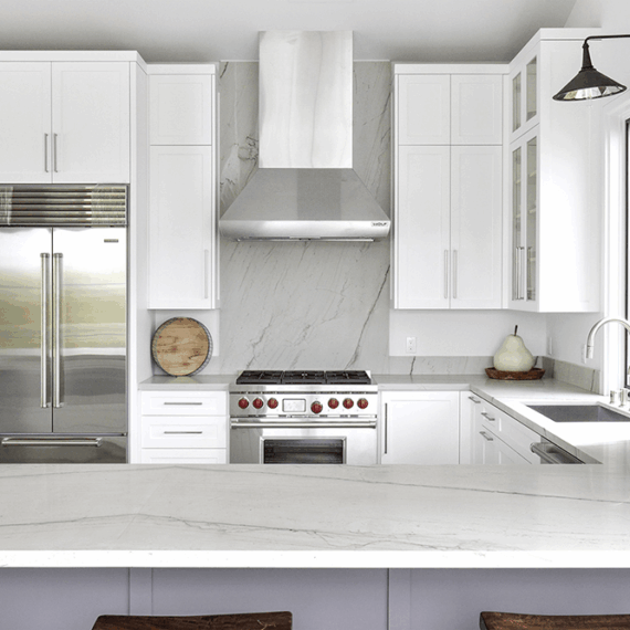 Stylish kitchen featuring Luce Di Luna quartzite countertops and a matching backsplash, complemented by stainless steel appliances and glass-front cabinets.