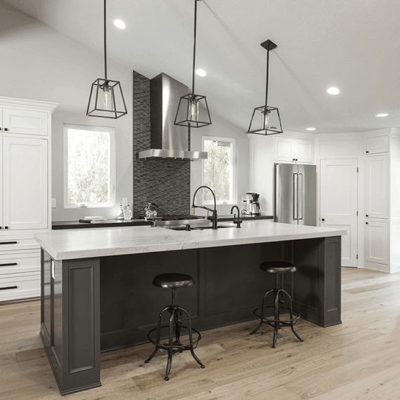 Modern kitchen island with a polished Luce Di Luna quartzite countertop, featuring elegant veining and a black base with matching bar stools.