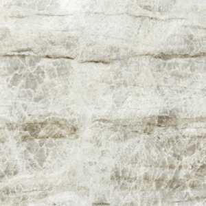 A close-up view of a Taj Mahal Premium Leathered Quartzite countertop slab featuring a creamy white background with elegant gold and brown veining and a textured matte finish.