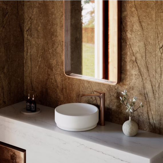 Modern powder room design with contrasting white mineral surface vanity and earthy stone wall cladding.