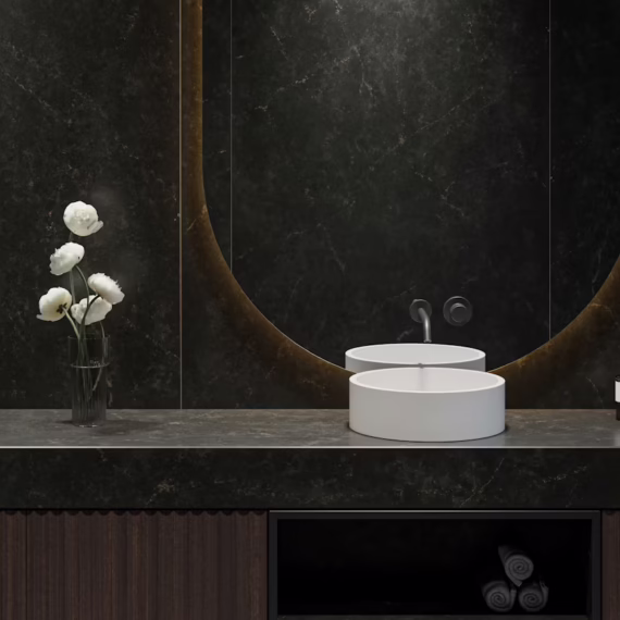 Luxury modern bathroom design featuring seamless matte charcoal stone wall paneling and matching vanity tops.