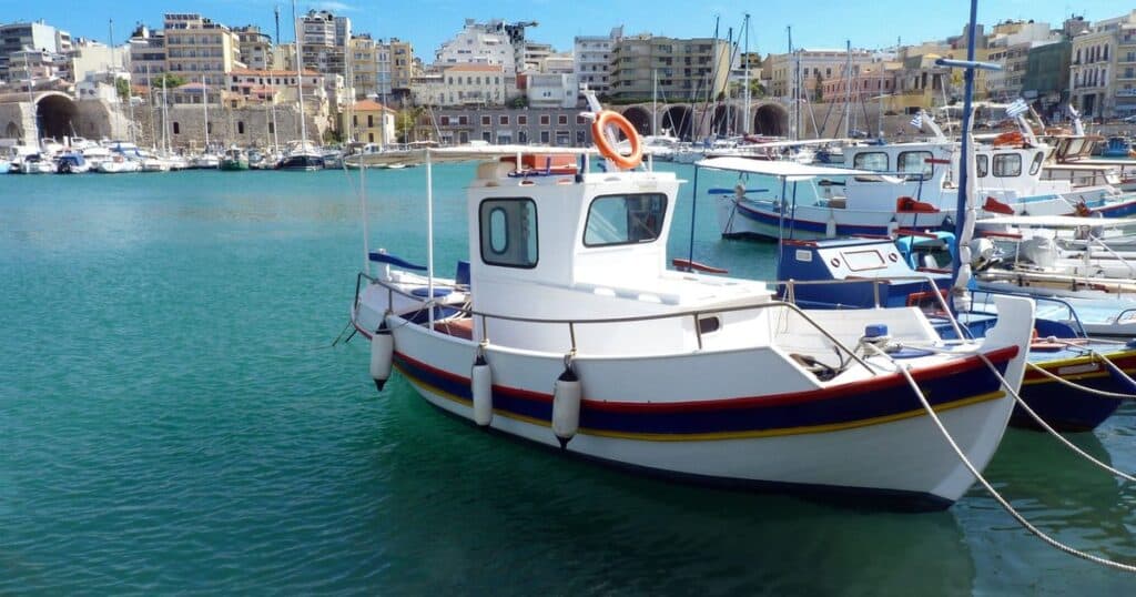 Λευκά σκάφη δεμένα στα γαλάζια νερά του λιμανιού