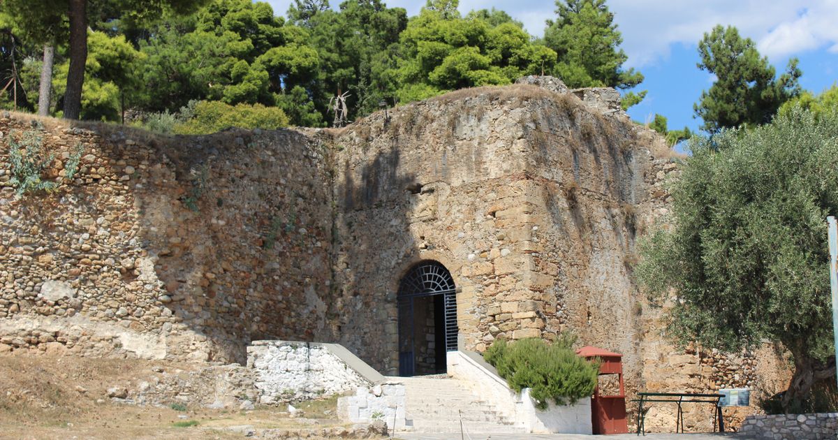 Η πέτρινη είσοδος του κάστρου της Καλαμάτας ανάμεσα σε πεύκα και ελιές.