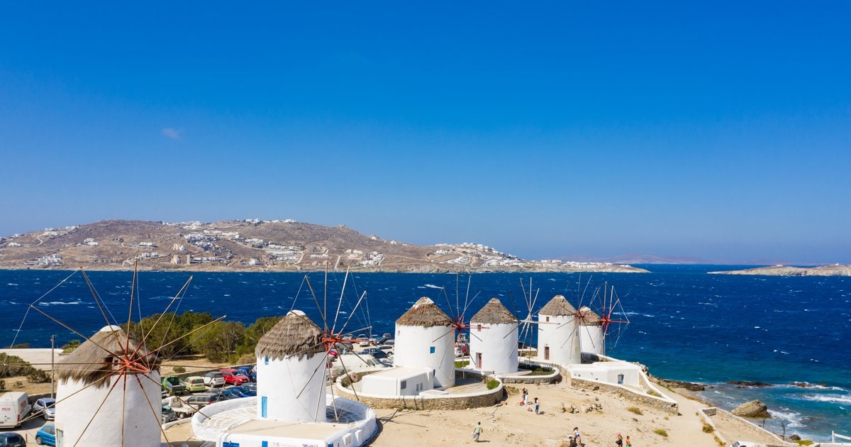 Οι ανεμόμυλοι της Μυκόνου πάνω από τη θάλασσα με τη Χώρα στο βάθος.