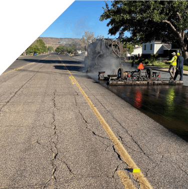 Asphalt paving machine laying fresh asphalt on a city street.
