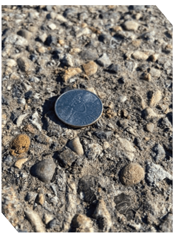 Close-up of asphalt surface with gravel and small stones for road paving.