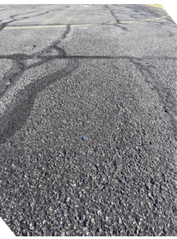 Close-up of asphalt surface with potholes and cracks for repair.