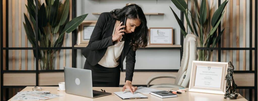 A professional woman lawyer multitasking in a modern office environment, reviewing documents. Astrology, Zodiac, Career, Starts