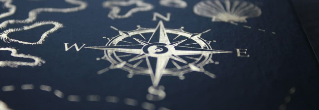 A close up of a compass on a table, midhaven, astrology, zodiac, career, entrepreneur