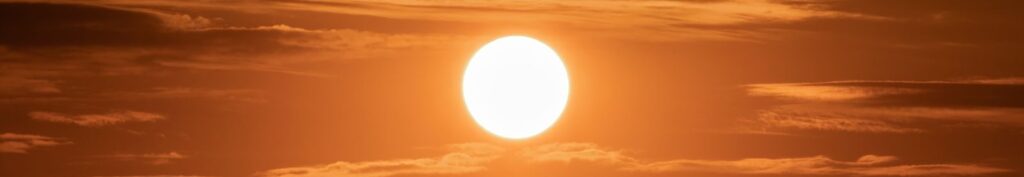 Captivating image of the sun setting over a vibrant golden sky filled with clouds, creating a dramatic scene.