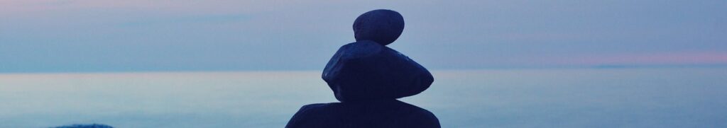 A calming seascape featuring stacked stones at twilight, symbolizing balance and tranquility.