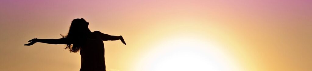 A joyful silhouette of a woman standing on a dock at sunset, embracing the freedom of nature.