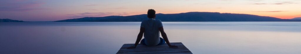 man siting on wooden dock