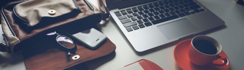 Stylish office workspace featuring a notebook, pen, laptop, and coffee cup on a tidy desk.