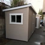 Durable beige wooden shed with white-framed window and door for garden storage.