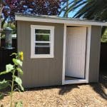 Small garden shed with window and door for storage or workspace.