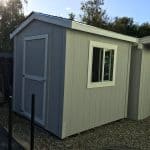 Modern gray garden shed with window and sloped roof, ideal for outdoor storage.