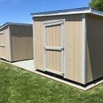 Garden shed with double doors, beige exterior, and white trim, ideal for outdoor storage solutions.