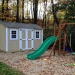 Backyard playhouse with slide and swings for kids.