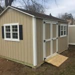 Garden shed with double doors, windows, and black shutters, ideal for storage or gardening tools.