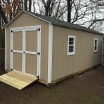 Garden storage shed with double doors, windows, and beige exterior for outdoor organization.