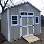 Garden shed with double doors, windows, and ramp for easy access.