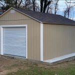 Garden shed with beige siding and white roll-up door for outdoor storage.