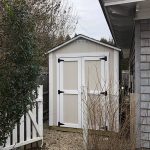Garden storage shed with double doors and black hardware, ideal for outdoor organization.