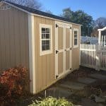 Durable beige garden shed with double doors and windows for outdoor storage.