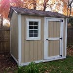 Small beige garden shed with white trim and window, outdoor backyard storage solution.