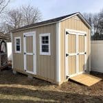 Beige garden shed with double doors, small windows, and ramp, ideal for outdoor storage.