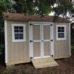 Garden shed with double doors, two windows, and ramp for easy access. Perfect for storage and outdoo.