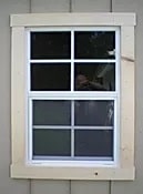 White framed window with six panes, showcasing shed design and quality.