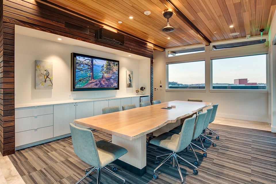 Zoom conference room in an office environment equipped with a TV and long meeting table