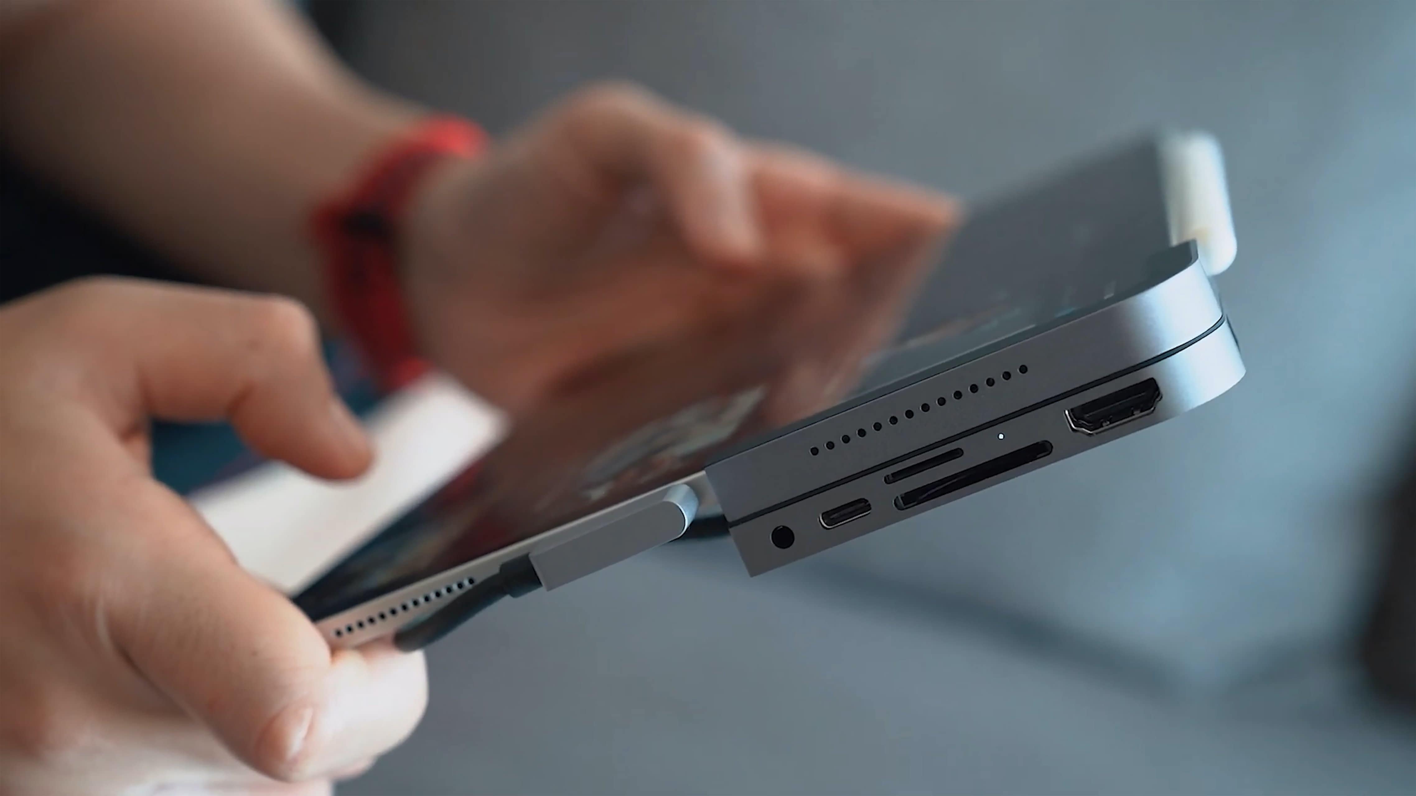 Person holding a tablet device and clicking something on its screen.
