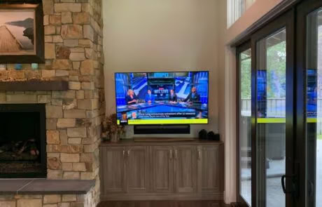 Living room smart TV and AV installation next to fireplace at Suncadia home