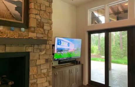 Living room TV and AV installation with fireplace and patio doors at Suncadia, WA home