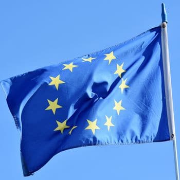 Europäische Union Flagge weht im Wind vor blauem Himmel.