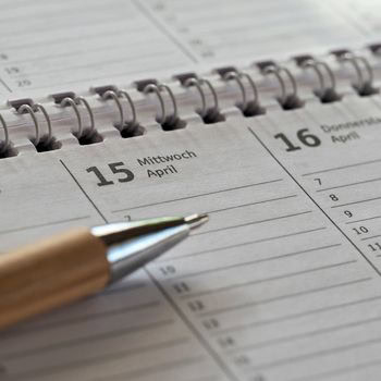Kalender mit Datum 15. April und Kugelschreiber.
