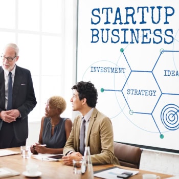 Geschäftsleute bei Startup-Strategie-Meeting mit Whiteboard.