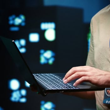 Person arbeitet an einem Laptop mit digitalem Hintergrund.