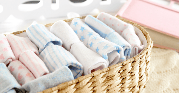 Soft baby socks in pastel colors arranged in a woven basket for newborn comfort and style.