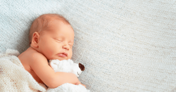 Soft baby sleeping peacefully on blanket with plush toy, cute newborn baby clothing and toy options.